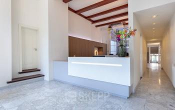 Interieur van kantoorpand op Keizersgracht 97-99, Amsterdam Grachtengordel met balie in de entreehal en marmeren vloer.