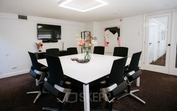 Vergaderruimte met zwarte stoelen en een grote tafel in kantoorpand op Keizersgracht 97-99, Amsterdam Grachtengordel.