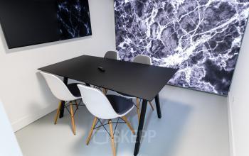 Moderne kantooromgeving met stijlvolle vergadertafel en artistieke wanddecoratie in kantoorpand aan Herengracht 168, Amsterdam Grachtengordel.