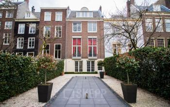Vooraanzicht van een kantoorpand gelegen aan de Herengracht 280 in de Amsterdam Grachtengordel met verzorgde tuin en klassieke gevel.
