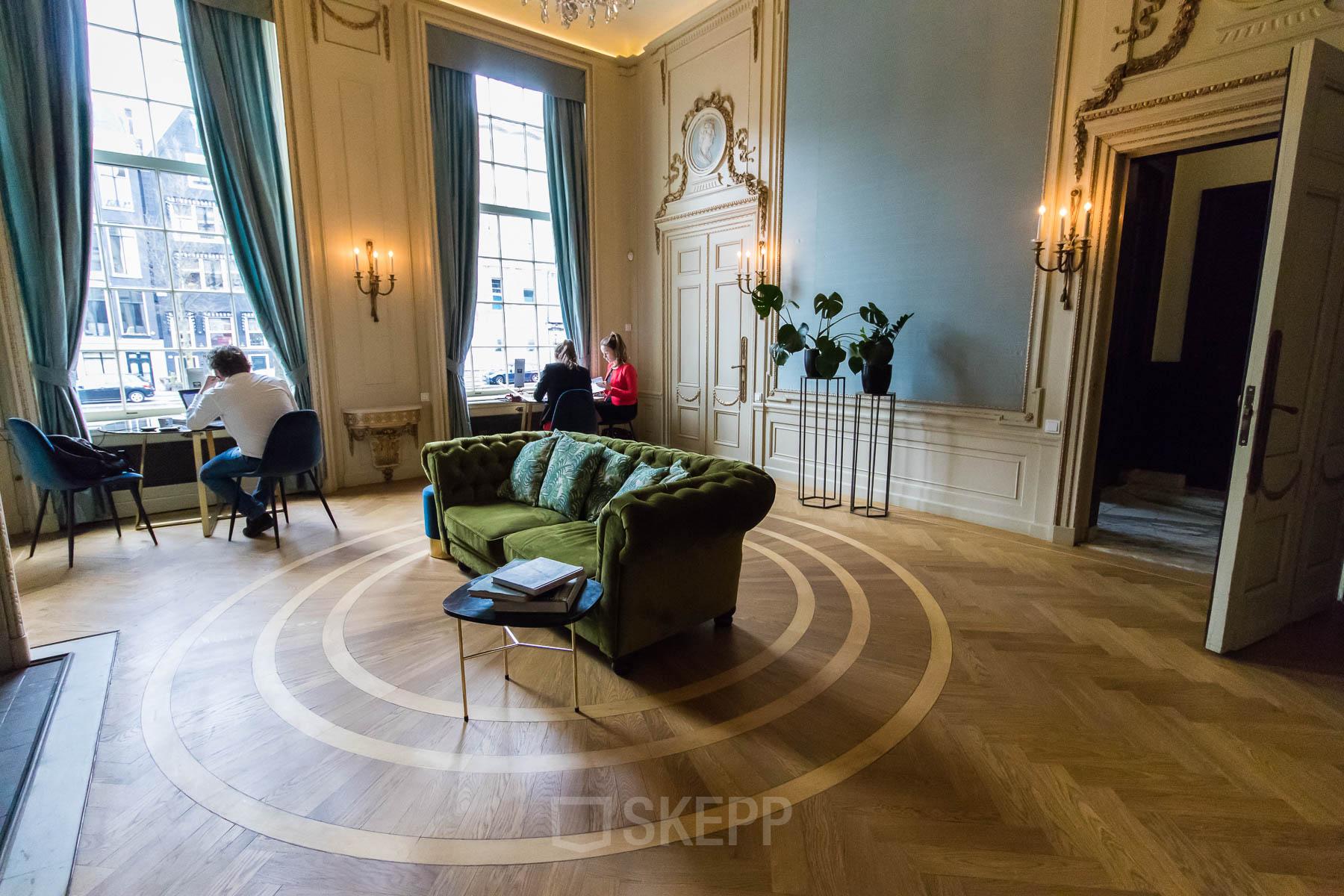 Kantoorruimte huren aan de Herengracht 280 in Amsterdam Grachtengordel, met stijlvolle inrichting en werkende mensen aan bureaus.
