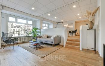 Lichte en ruime kantoorruimte huren aan de Amstel 62, Amsterdam Grachtengordel, met houten vloer, moderne meubels en grote ramen met uitzicht.