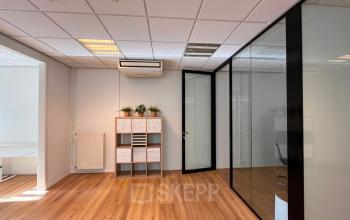 Moderne kantoorruimte huren in Amsterdam Grachtengordel aan Amstel 62 met glazen wand en houten vloer.