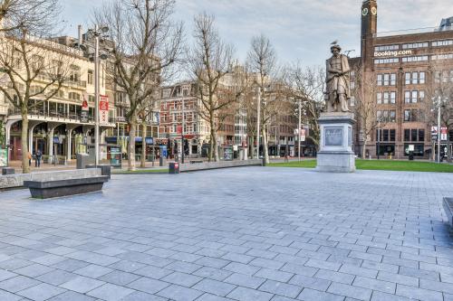 Exterieur van het kantoorpand Amstel 62 in de Amsterdam Grachtengordel, omgeven door historische gebouwen en een open plein met standbeeld.