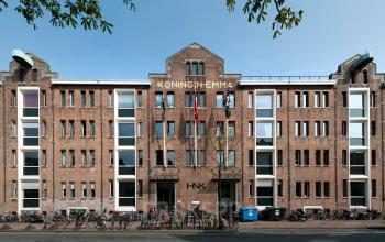 Buitenkant van kantoorpand op Van Diemenstraat 20-200 in Amsterdam Houthavens. Bakstenen gebouw met meerdere ramen en fietsen geparkeerd voor de ingang.