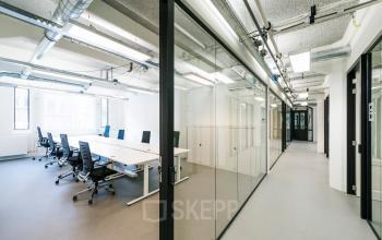 Moderne kantoorruimte met glazen scheidingswanden, vergadertafel en ergonomische stoelen op Van Diemenstraat 20-200 in Amsterdam Houthavens, ideaal om kantoorruimte te huren.