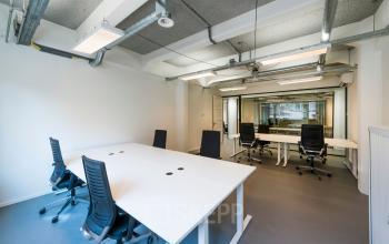 Een moderne en lichte kantoorruimte op Van Diemenstraat 20-200 in Amsterdam Houthavens met witte bureaus en zwarte stoelen, ideaal voor wie kantoorruimte wil huren.