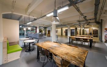 Kantoorruimte te huur aan Van Diemenstraat 20-200 in Amsterdam Houthavens, met een creatieve, moderne inrichting, houten tafels en open indeling.