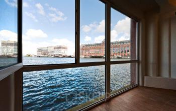 Grote glazen ramen in een kantoorpand met uitzicht over het water in Amsterdam Houthavens, ideaal voor kantoorruimte huren.