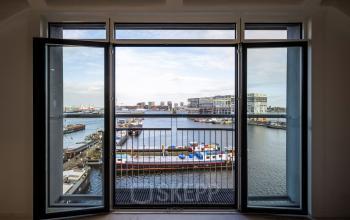 Uitzicht vanuit kantoor op Van Diemenstraat 20-200, Amsterdam Houthavens, met open ramen en een uitzicht op de haven.