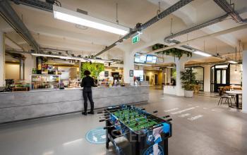 Kantoorruimte huren in Amsterdam Houthavens op Van Diemenstraat 20-200, met een modern interieur en speelse sfeer inclusief een voetbaltafel en bar.