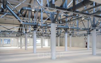 Ruime en lichte kantoorruimte in Amsterdam Houthavens met industriële elementen en buizen zichtbaar. Geschikt voor kantoorruimte huren op Van Diemenstraat 20-200.