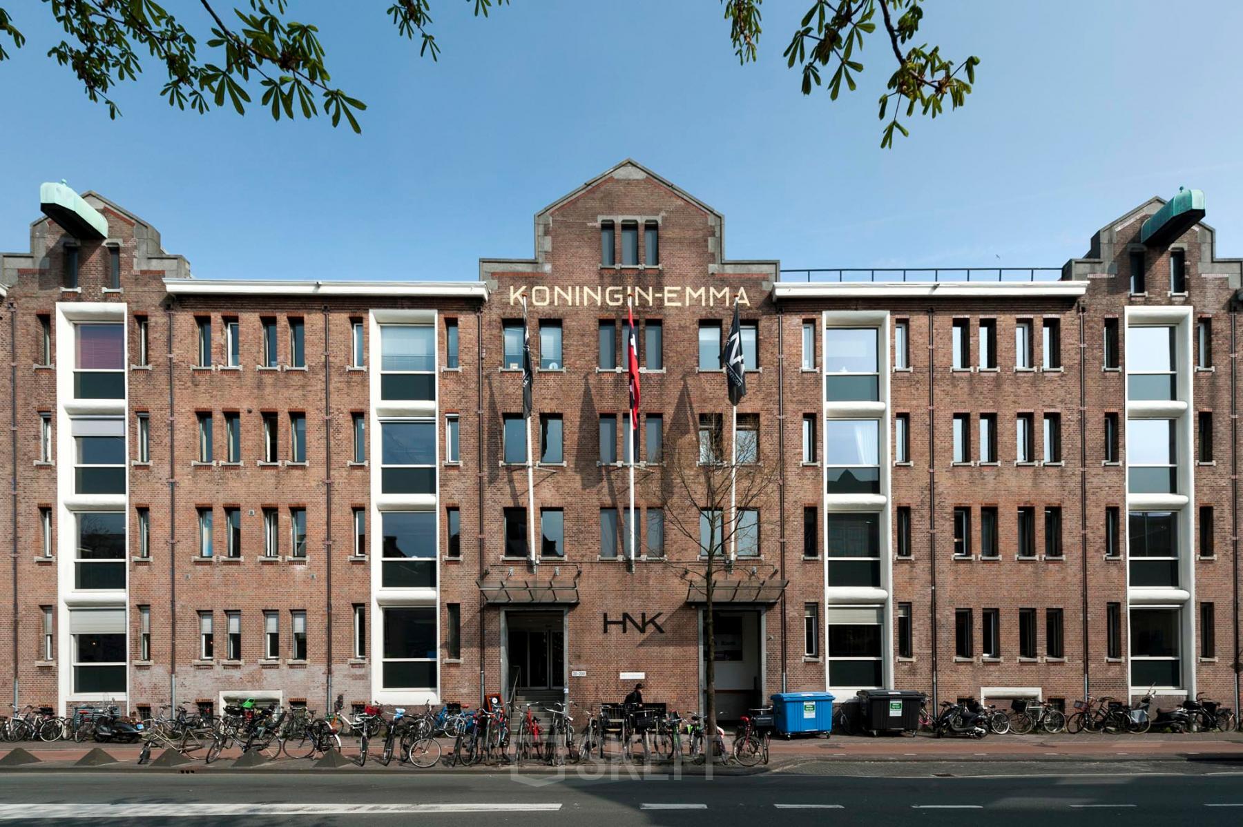Buitenkant van kantoorpand op Van Diemenstraat 20-200 in Amsterdam Houthavens. Bakstenen gebouw met meerdere ramen en fietsen geparkeerd voor de ingang.