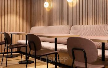 Stijlvolle kantoorruimte op Overschiestraat 65 in Amsterdam Nieuw-West met houten paneelwanden en elegante zitplekken om klanten te ontvangen.