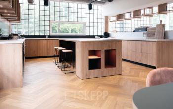 Moderne pantry in kantoorpand aan de Overschiestraat 65, Amsterdam Nieuw-West, met stijlvol meubilair en natuurlijk licht.