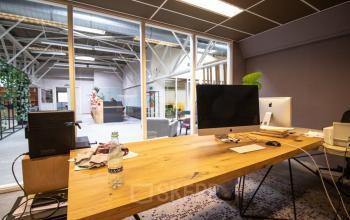 Interieur van een kantoor aan de Anthony Fokkerweg 3, Amsterdam Nieuw-West. Werkplekken met houten tafels, moderne apparatuur en planten voor een productieve sfeer. Kantoorruimte huren in een inspirerende omgeving.