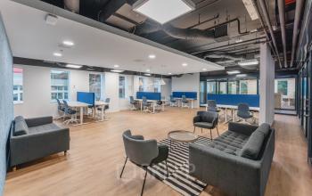 Interieur van een kantoorpand aan het Koningin Wilhelminaplein 1 in Amsterdam Nieuw-West met moderne werkplekken, vergadertafels en zithoeken voor overleg; ideaal voor bedrijven die kantoorruimte huren.