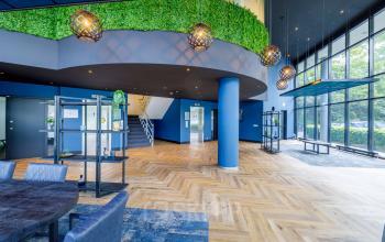 Representatief interieur van kantoorpand op Overschiestraat 61 in Amsterdam Nieuw-West, met ruime ontvangsthal, moderne inrichting en groene accenten. Ideale kantoorruimte huren in een inspirerende omgeving.