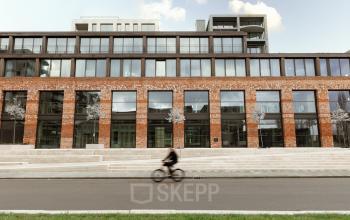 Modern kantoorpand met bakstenen gevel en grote ramen aan de Papaverhof 58, Amsterdam Noord. Geschikt voor kantoorruimte huren met een eigentijdse uitstraling.