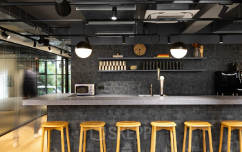 Stijlvolle en moderne kantoorruimte in Amsterdam Noord met een strakke bar en hoge krukken. Ideaal voor huur als onderdeel van een kantoor met voorzieningen in het kantoorpand.