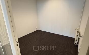 Lege kantoorruimte te huur op Buikslotermeerplein 430, Amsterdam Noord, met witte muren en bruine vloerbedekking. Ideaal voor het personaliseren van uw eigen kantoorpand.