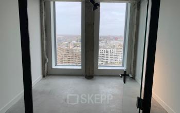 Ongebruikte kantoorruimte te huur op Overhoeksplein 1 in Amsterdam Noord met uitzicht op de stad door grote ramen.