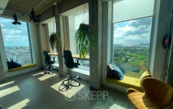 Kantoorruimte huren met panoramisch uitzicht op Amsterdam Noord vanaf Overhoeksplein 1, voorzien van comfortabele zithoek met planten.