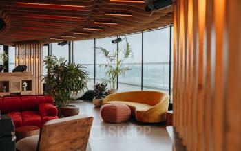 Gezellige kantoorruimte te huur op Overhoeksplein 1 in Amsterdam Noord, met houten interieur en grote ramen voor veel natuurlijk licht. Ideaal voor een creatieve werkomgeving.