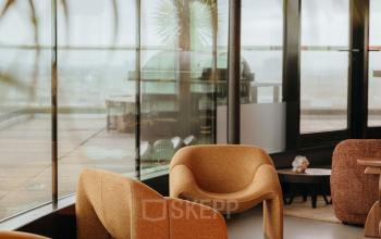 Moderne kantoorruimte aan Overhoeksplein 1, Amsterdam Noord, met elegante stoelen en grote ramen met uitzicht. Ideale locatie om een kantoor te huren.