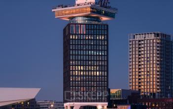 Kantoorgebouw op Overhoeksplein 1 in Amsterdam Noord, direct aan het IJ, met een indrukwekkende moderne architectuur. Ideaal voor bedrijf dat kantoorruimte wil huren in een iconische omgeving.