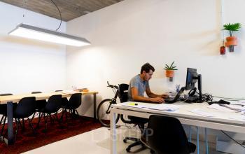 Moderne kantoorruimte op Asterweg 19 in Amsterdam Noord met een persoon geconcentreerd werkend aan een bureau.