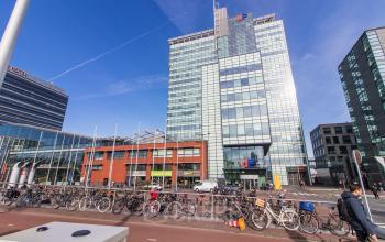 Moderne glazen gevel van het kantoorpand op Piet Heinkade 55 in Amsterdam Oost, met fietsen voor het gebouw. Ideaal voor kantoorruimte huren.
