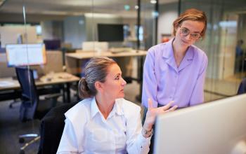 Kantoorruimte huren in Amsterdam Oost met moderne werkplekken; medewerkers in overleg bij computer in kantoorpand op Science Park 301.