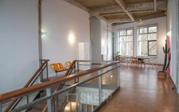 Kantoorruimte op KNSM-Laan 171 in Amsterdam Oost met ruime lichte gangen, zittingen langs de wand en een grote tafel bij het raam, ideaal voor vergaderingen.