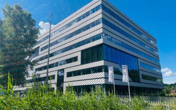 Modern kantoorpand op Science Park 301 in Amsterdam Oost met glas en staal, geschikt voor kantoorruimte huren. Omgeven door groen en een heldere lucht.