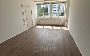 Lege kantoorruimte met grote ramen aan de James Wattstraat 71, Amsterdam Oost, ideaal voor huurkandidaten die een lichte en functionele werkplek zoeken.
