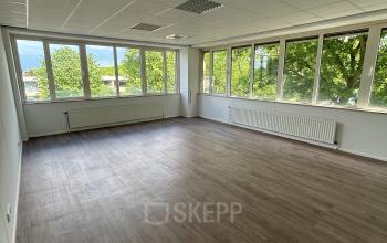 Lichte kantoorruimte te huur op James Wattstraat 71, Amsterdam Oost, met grote ramen en uitzicht op groen. Ideaal voor een veelzijdige invulling van werkruimte.