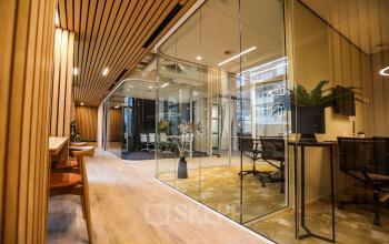 Stijlvolle kantoorruimte te huur aan Apollolaan 151, Amsterdam Oud Zuid, met glazen wanden en moderne inrichting. Ideaal voor zakelijke bijeenkomsten of werkplekken.