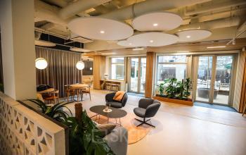 Moderne kantoorruimte huren aan Apollolaan 151, Amsterdam Oud Zuid, met stijlvolle zitgedeelte en grote ramen voor veel natuurlijk licht.