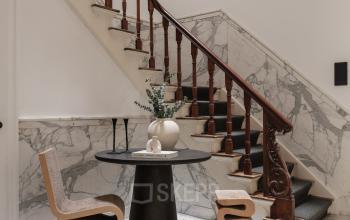 Hal van kantoorpand aan de Jacob Obrechtstraat 56 in Amsterdam Oud Zuid met marmeren vloeren, houten trapleuning en kunstzinnige meubels. Ideaal voor kantoorruimte huren.