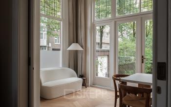 Kantoorruimte huren in Amsterdam Oud Zuid op Jacob Obrechtstraat 56 met een gemeubileerd interieur met grote ramen en houten vloeren.