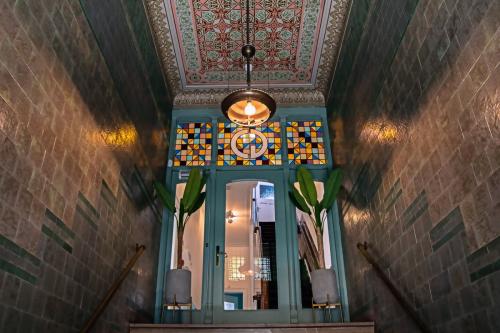 Historisch entree van het kantoorpand aan Emmalaan 7-9 in Amsterdam Oud Zuid, met kleurrijke ramen en gedetailleerd plafond.