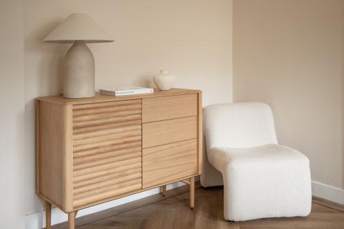 Stijlvolle hoek in een kantoorpand met een houten kast en een moderne stoel op Emmalaan 7-9, Amsterdam Oud Zuid.