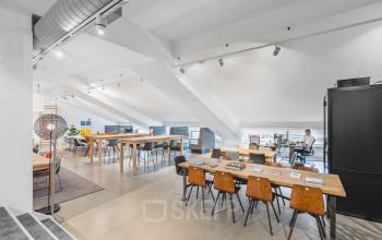 Ruime kantoorruimte huren in het Olympisch Stadion, Amsterdam Oud Zuid met moderne werkplekken en industriële elementen. Ideaal voor co-working en flexwerkplekken.