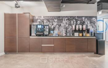 Een moderne koffiehoek in een kantoorpand aan het Olympisch Stadion 24-28, Amsterdam Oud Zuid. Voorzien van een koffieautomaat en meerdere drankdispensers, ideaal voor kantoorruimte huren.