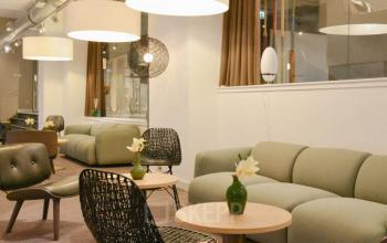 Interieur van kantoorpand aan Olympisch Stadion 24-28 in Amsterdam Oud Zuid, met moderne gemeubileerde lounge ruimte met banken en stoelen.