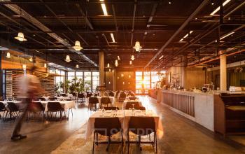 Gezellig ingerichte ontmoetingsruimte met gedekte tafels, ideaal voor informele bijeenkomsten in kantoorpand Johan Huizingalaan 400, Amsterdam Riekerpolder.