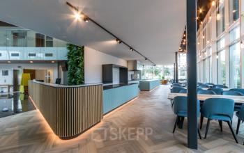 Moderne kantoorruimte huren op John M. Keynesplein 4-10 in Amsterdam Riekerpolder, met een stijlvolle inrichting en houten vloeren.