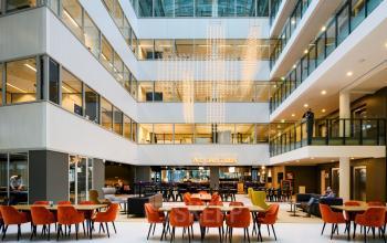 Kantoorruimte huren in een modern kantoorpand aan Thomas R. Malthusstraat 1-3, Amsterdam Riekerpolder, met open gemeenschappelijke ruimte en zitgedeelte.