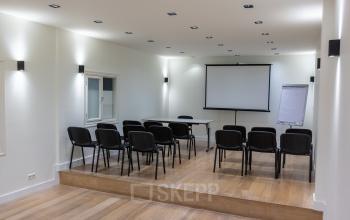 Kantoorruimte huren op Poortland 66 in Amsterdam Sloterdijk met moderne vergaderfaciliteiten, inclusief projector en stoelen, ideaal voor zakelijke bijeenkomsten of presentaties.